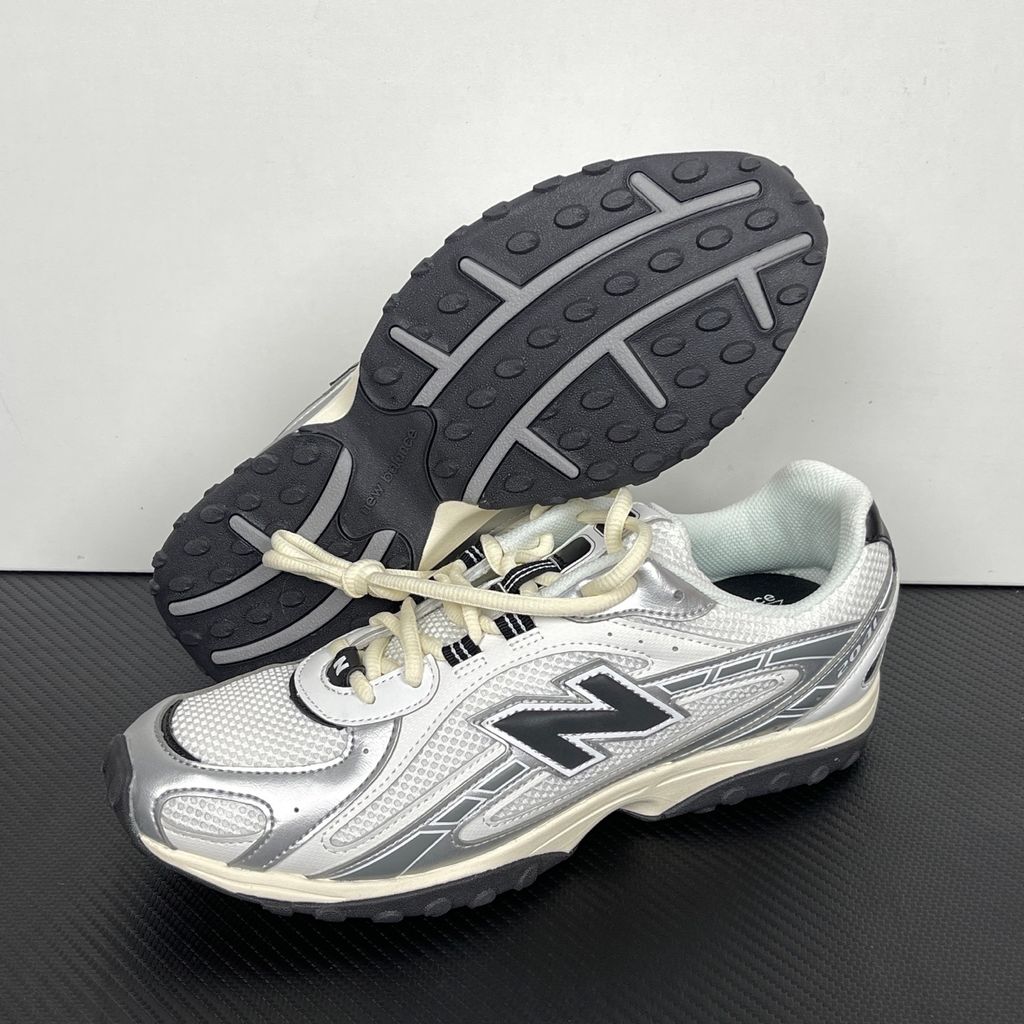 Side profile of the New Balance 204L 'Silver Metallic Black', showcasing the breathable black mesh upper, dynamic silver metallic synthetic overlays, classic 'N' logo, and a sleek, cushioned runner midsole.