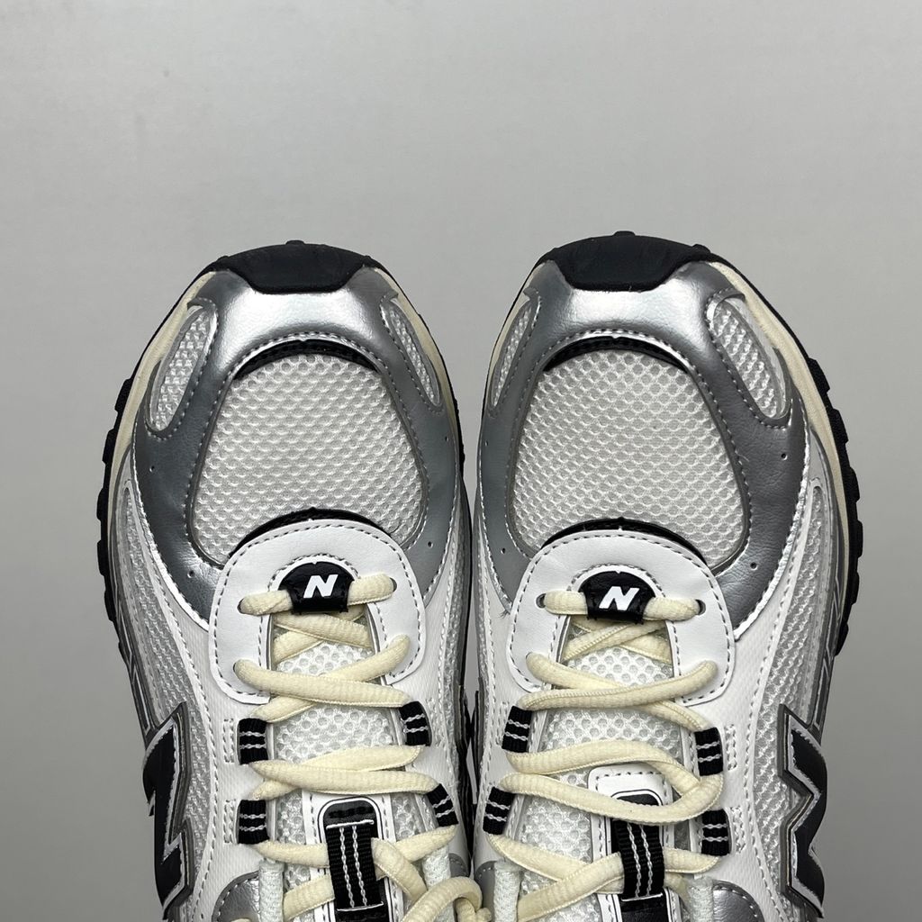 Side profile of the New Balance 204L 'Silver Metallic Black', showcasing the breathable black mesh upper, dynamic silver metallic synthetic overlays, classic 'N' logo, and a sleek, cushioned runner midsole.
