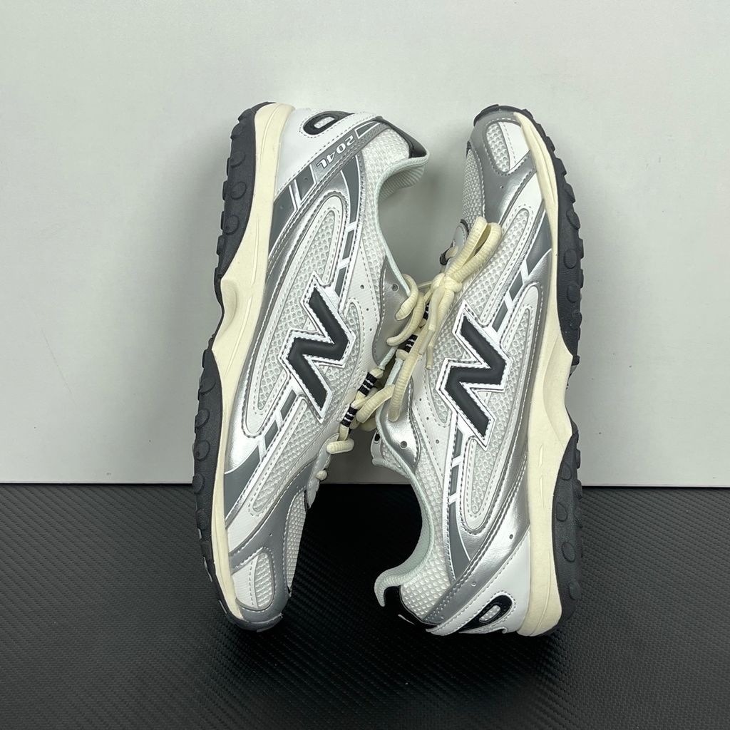 Side profile of the New Balance 204L 'Silver Metallic Black', showcasing the breathable black mesh upper, dynamic silver metallic synthetic overlays, classic 'N' logo, and a sleek, cushioned runner midsole.