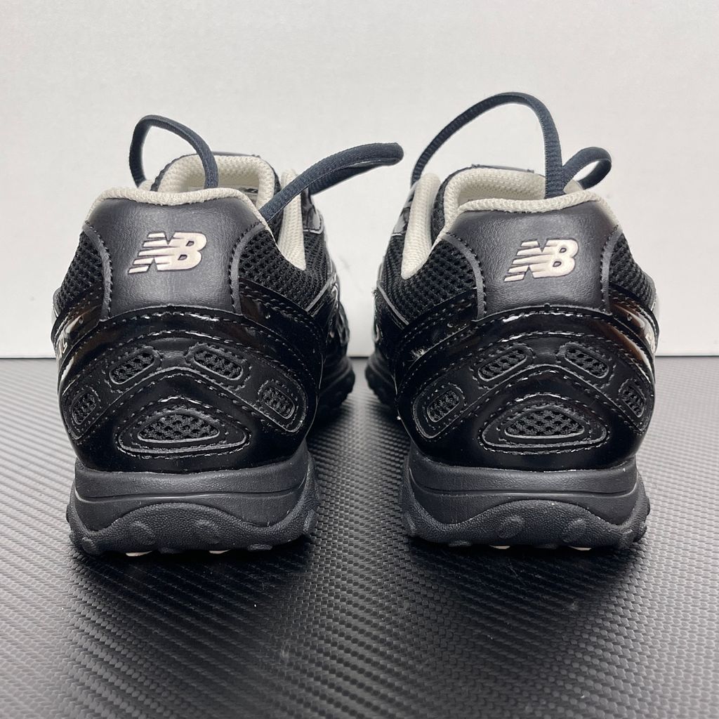 Side profile of the New Balance 204L 'Black Timberwolf', showcasing the breathable black mesh upper, dynamic taupe-grey Timberwolf synthetic overlays, classic 'N' logo, and a sleek, cushioned runner midsole.
