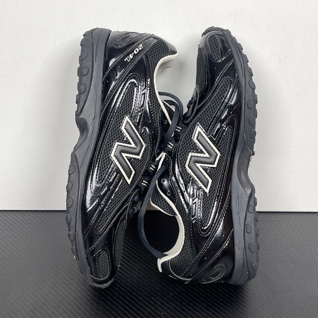 Side profile of the New Balance 204L 'Black Timberwolf', showcasing the breathable black mesh upper, dynamic taupe-grey Timberwolf synthetic overlays, classic 'N' logo, and a sleek, cushioned runner midsole.