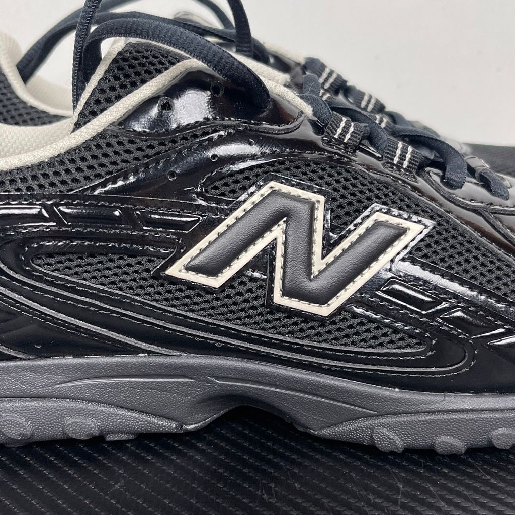 Side profile of the New Balance 204L 'Black Timberwolf', showcasing the breathable black mesh upper, dynamic taupe-grey Timberwolf synthetic overlays, classic 'N' logo, and a sleek, cushioned runner midsole.
