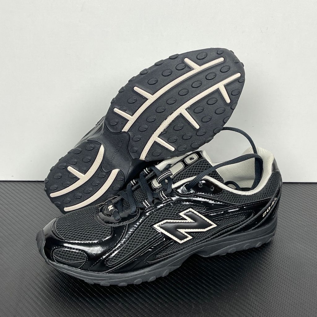 Side profile of the New Balance 204L 'Black Timberwolf', showcasing the breathable black mesh upper, dynamic taupe-grey Timberwolf synthetic overlays, classic 'N' logo, and a sleek, cushioned runner midsole.