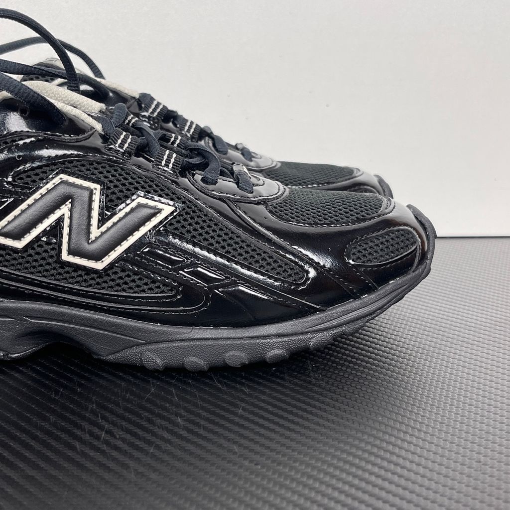 Side profile of the New Balance 204L 'Black Timberwolf', showcasing the breathable black mesh upper, dynamic taupe-grey Timberwolf synthetic overlays, classic 'N' logo, and a sleek, cushioned runner midsole.