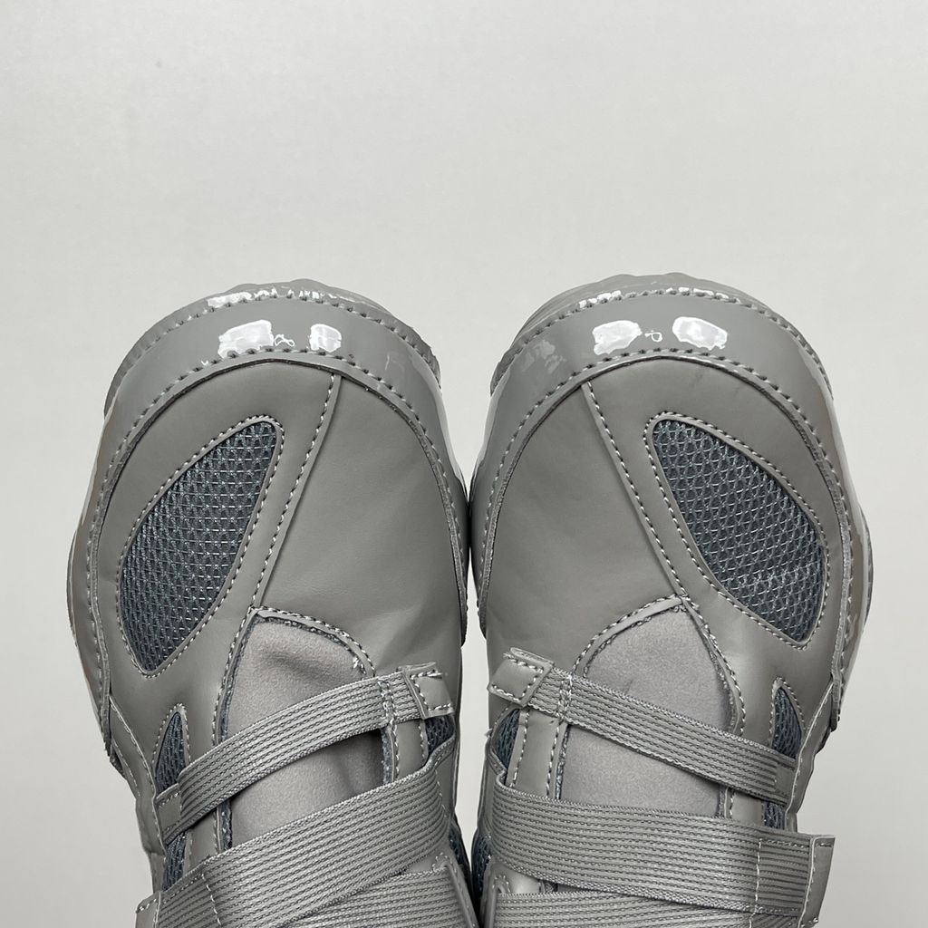 Side profile of the ASICS Hyper Taping x Issey Miyake in a monochromatic grey colorway, showcasing the sleek minimalist upper, intricate structural tape overlays, and streamlined tonal midsole.
