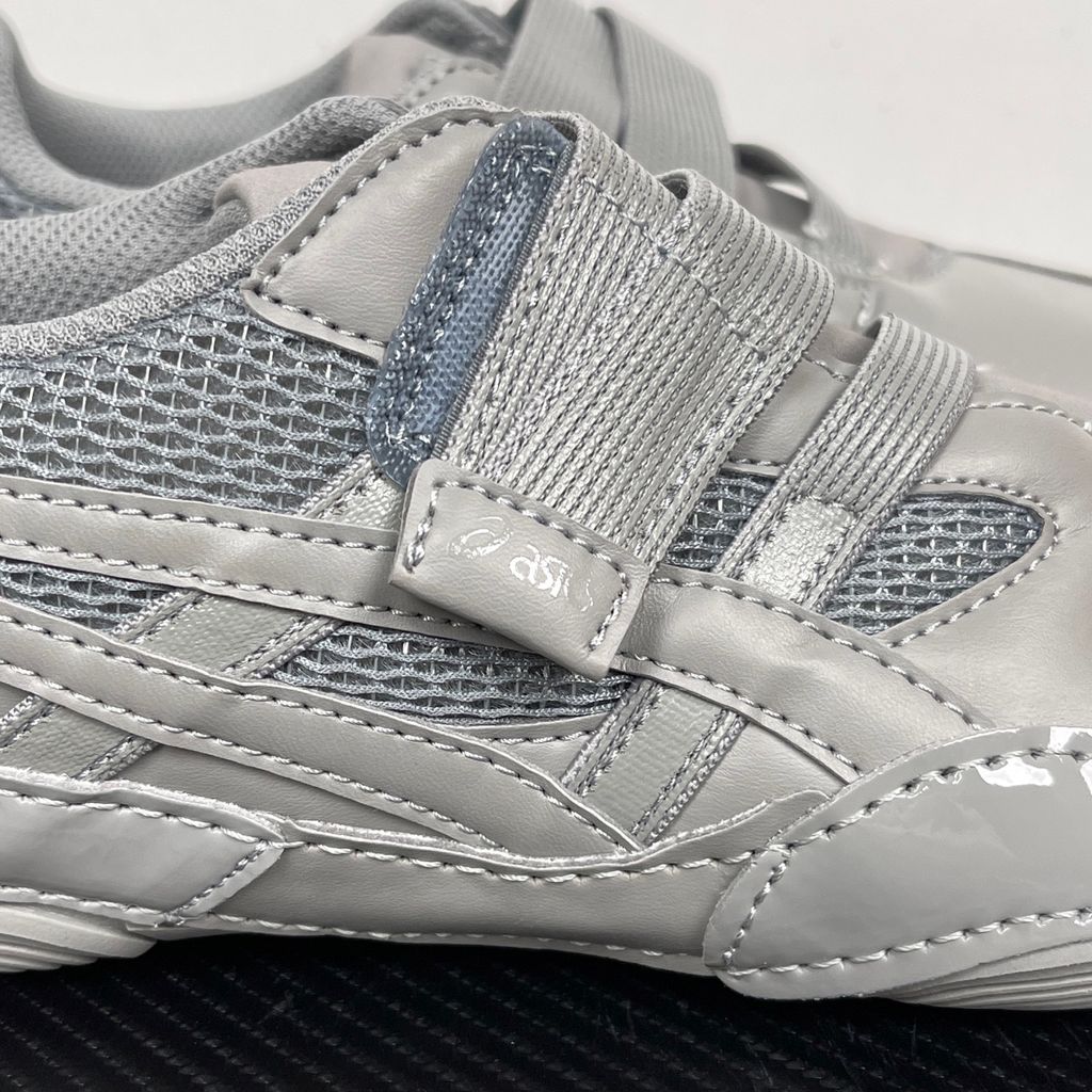 Side profile of the ASICS Hyper Taping x Issey Miyake in a monochromatic grey colorway, showcasing the sleek minimalist upper, intricate structural tape overlays, and streamlined tonal midsole.