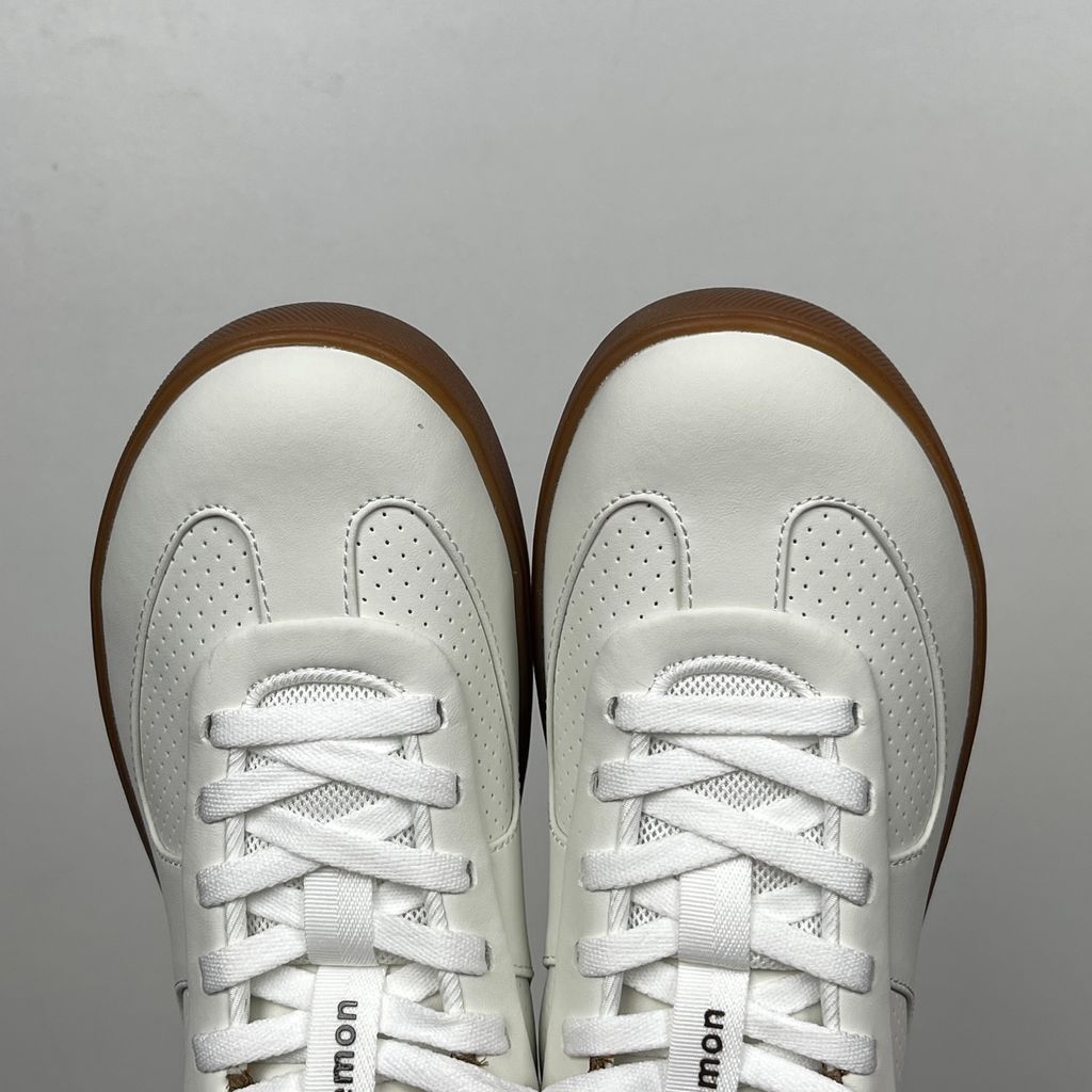 Side profile of the lululemon Cityverse Perforated Sneaker, showcasing the clean white leather upper with custom perforation patterns, a supportive gum rubber midsole, and a faux-fur leopard print heel tab.