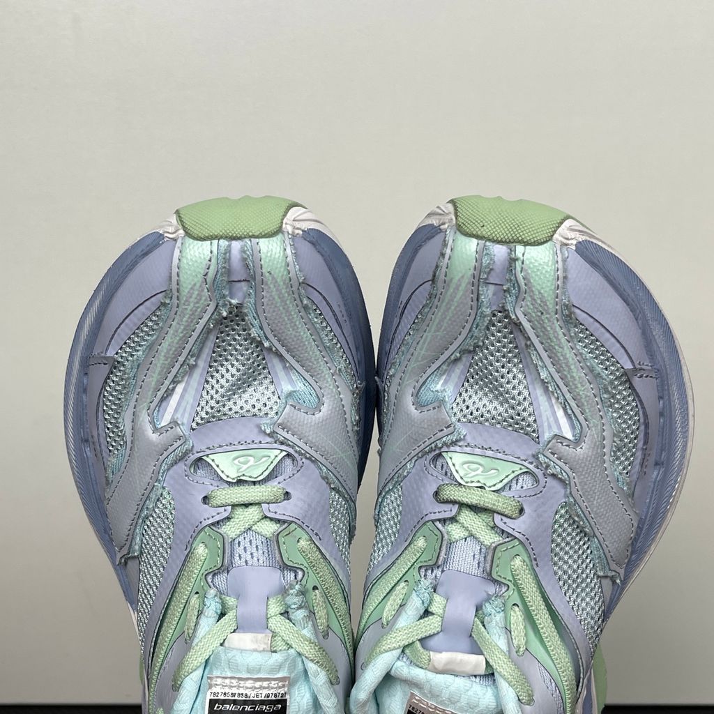 Side profile of the Balenciaga Jet Sneaker, showcasing the pastel light blue, lilac, and mint green layered mesh upper with heavy distressing and frayed edges, seated on a massively chunky, aerodynamic rocker-shaped midsole.