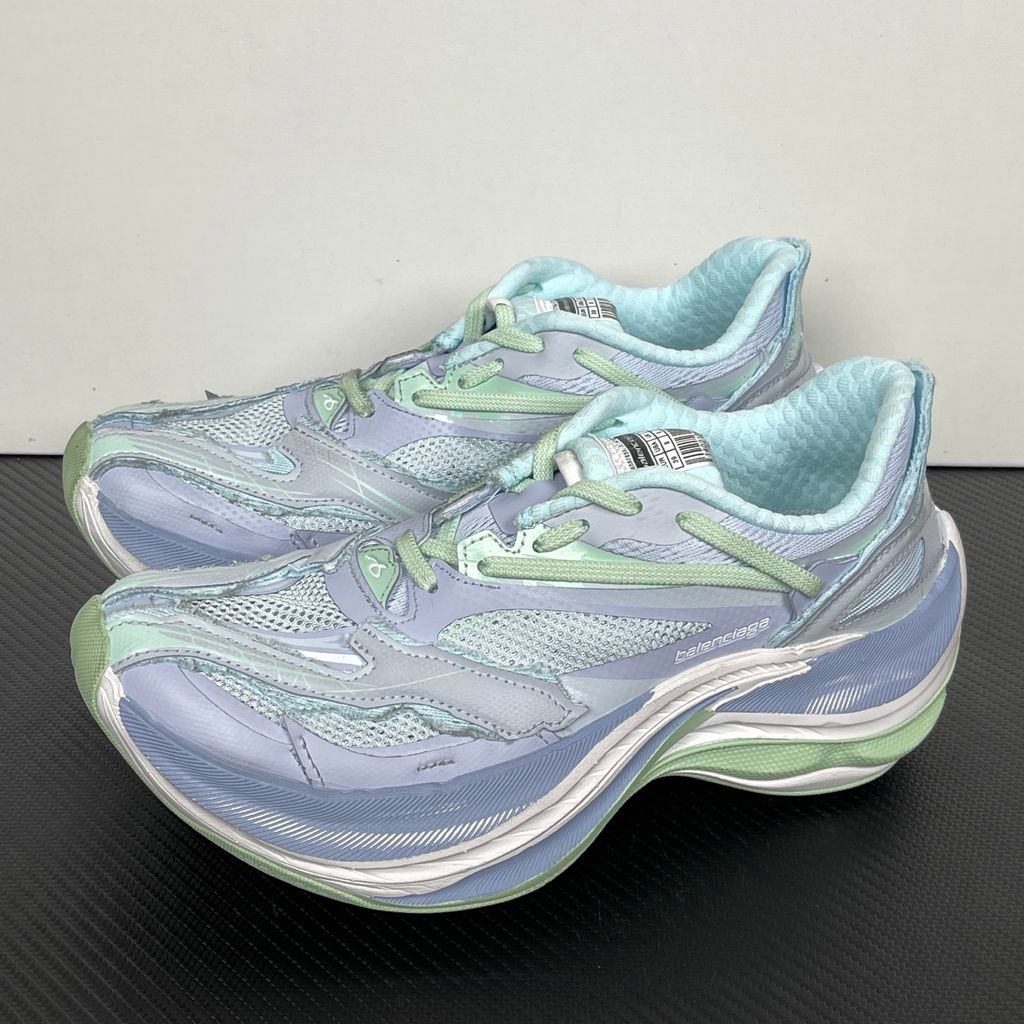 Side profile of the Balenciaga Jet Sneaker, showcasing the pastel light blue, lilac, and mint green layered mesh upper with heavy distressing and frayed edges, seated on a massively chunky, aerodynamic rocker-shaped midsole.