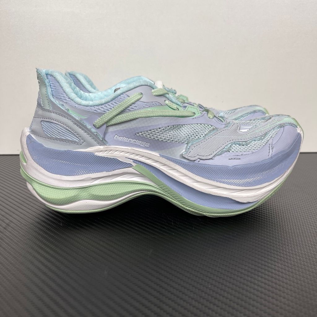 Side profile of the Balenciaga Jet Sneaker, showcasing the pastel light blue, lilac, and mint green layered mesh upper with heavy distressing and frayed edges, seated on a massively chunky, aerodynamic rocker-shaped midsole.