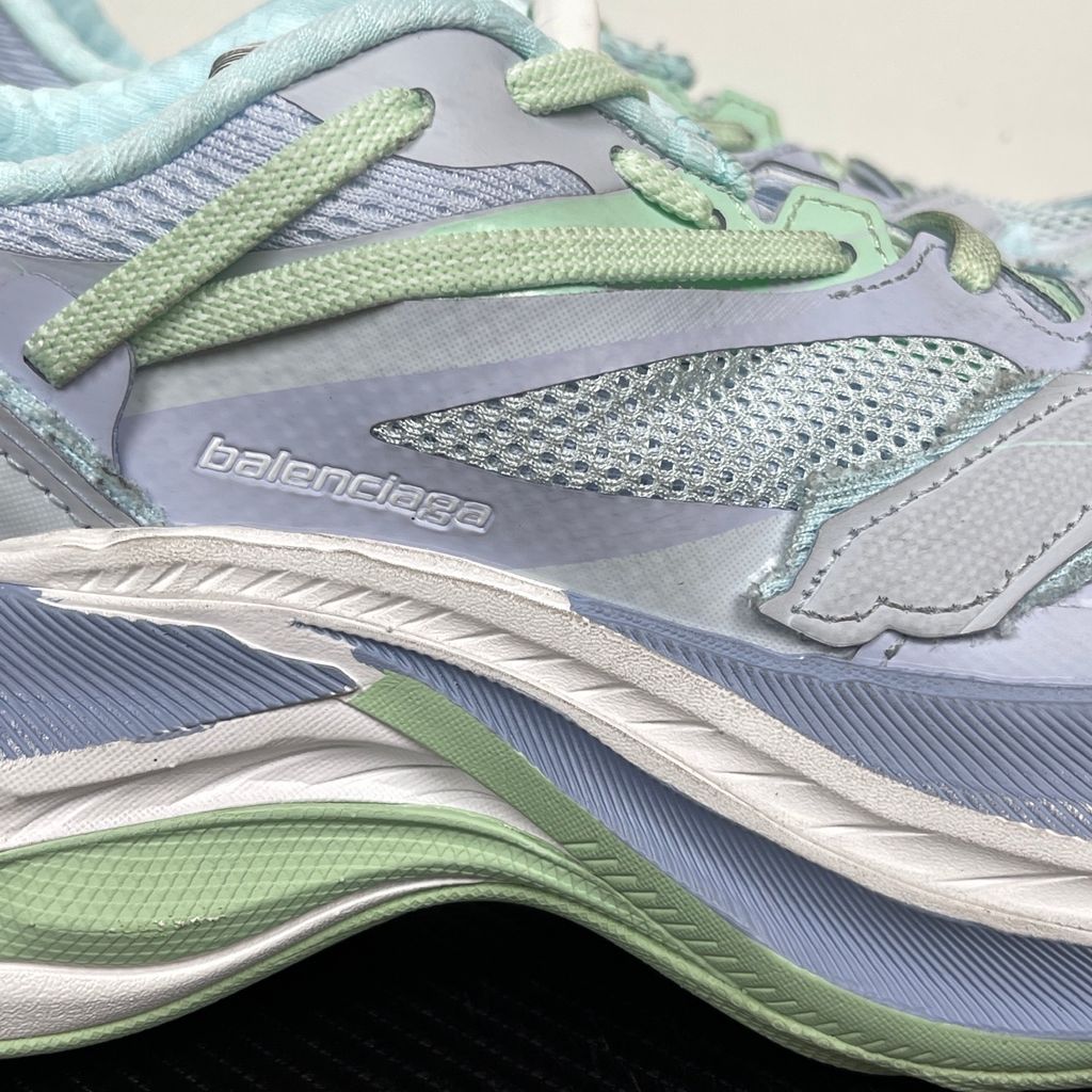 Side profile of the Balenciaga Jet Sneaker, showcasing the pastel light blue, lilac, and mint green layered mesh upper with heavy distressing and frayed edges, seated on a massively chunky, aerodynamic rocker-shaped midsole.