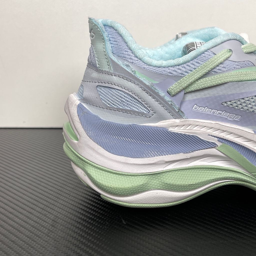 Side profile of the Balenciaga Jet Sneaker, showcasing the pastel light blue, lilac, and mint green layered mesh upper with heavy distressing and frayed edges, seated on a massively chunky, aerodynamic rocker-shaped midsole.