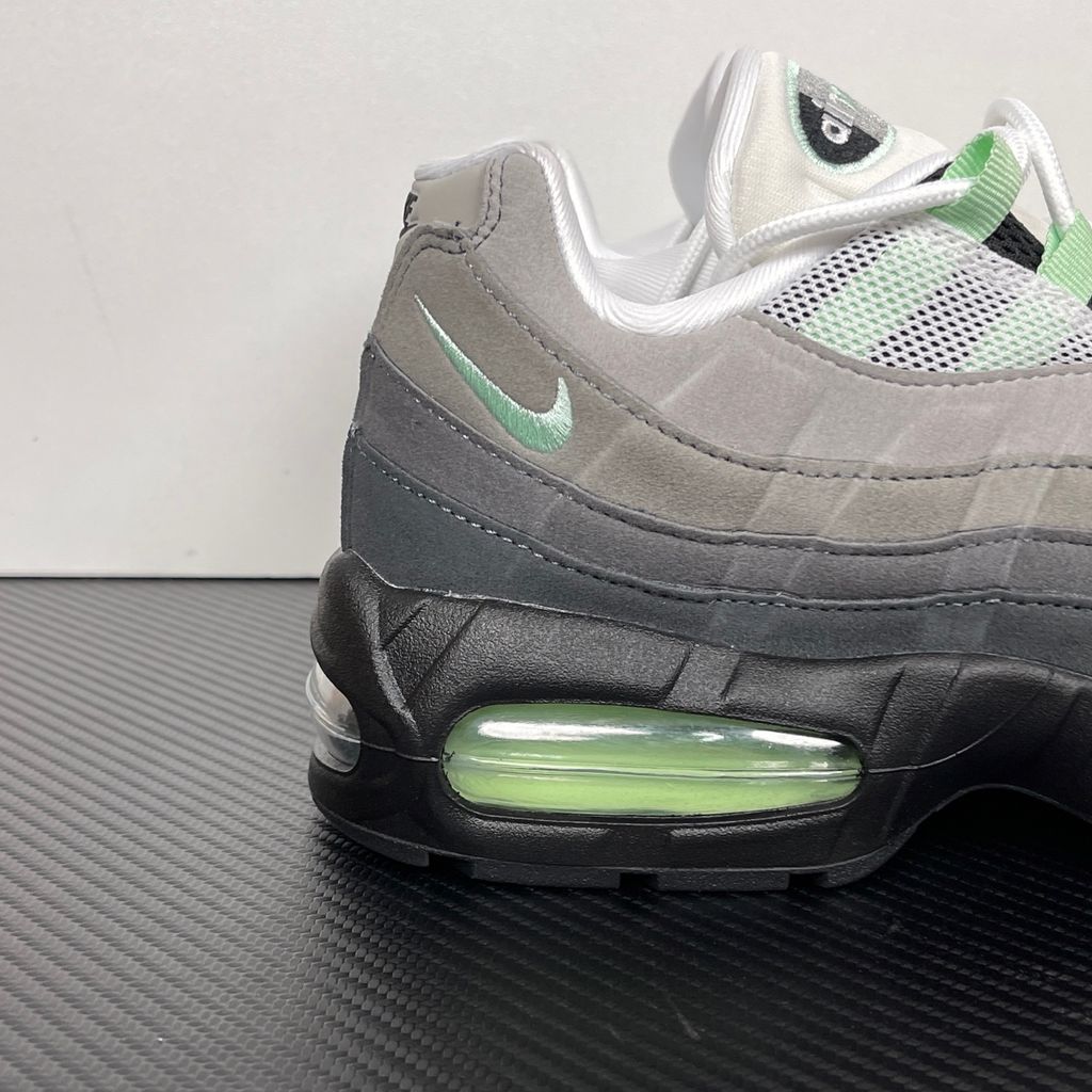 Side profile of the women's Nike Air Max 95 OG 'Big Bubble' Fresh Mint, showcasing the classic grey gradient anatomy-inspired upper, vibrant mint green lace loops and Swoosh, and the exaggerated visible Air units housed within a black midsole.