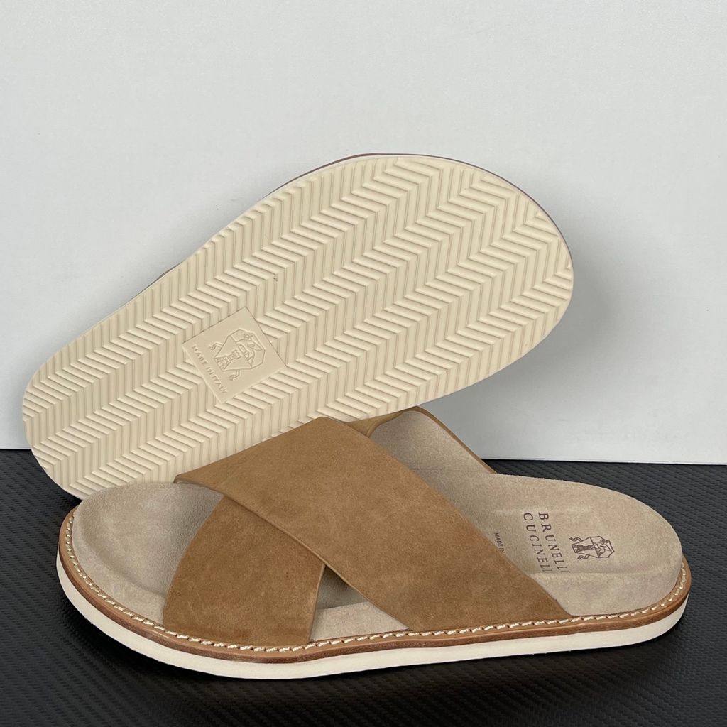 Top-down view of the Brunello Cucinelli suede sandals, showcasing the criss-cross bronze brown straps, soft beige footbed with official stamped branding, and meticulous Italian welt stitching.