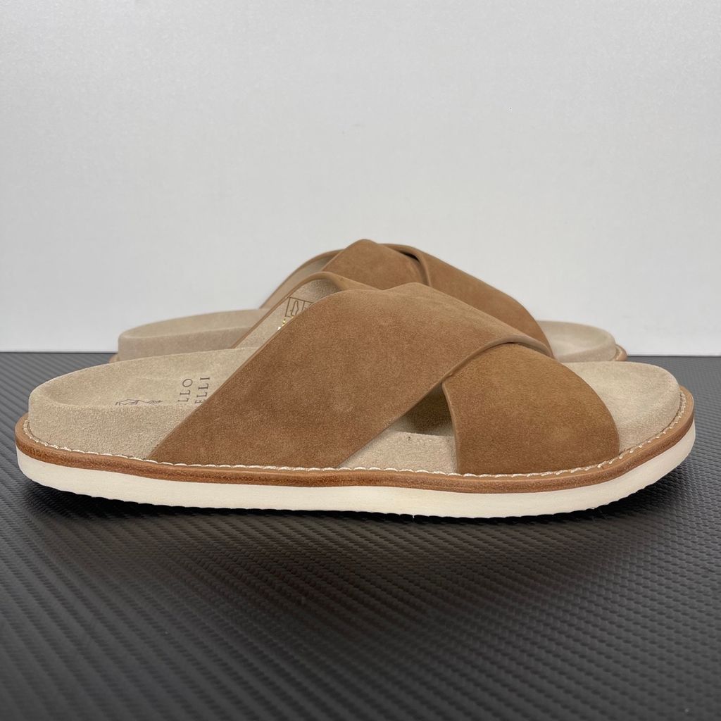 Top-down view of the Brunello Cucinelli suede sandals, showcasing the criss-cross bronze brown straps, soft beige footbed with official stamped branding, and meticulous Italian welt stitching.