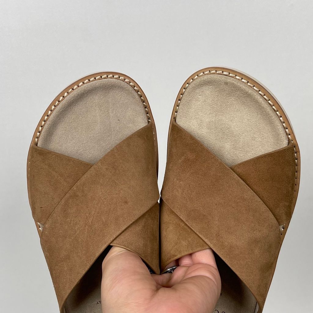 Top-down view of the Brunello Cucinelli suede sandals, showcasing the criss-cross bronze brown straps, soft beige footbed with official stamped branding, and meticulous Italian welt stitching.