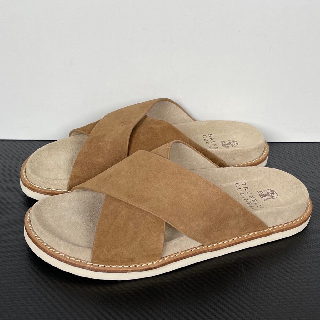 Top-down view of the Brunello Cucinelli suede sandals, showcasing the criss-cross bronze brown straps, soft beige footbed with official stamped branding, and meticulous Italian welt stitching.