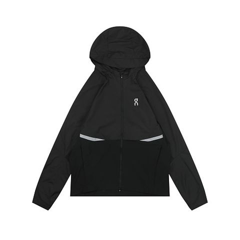 Front profile of the men's On Running Core Jacket in black, showcasing the lightweight windproof fabric, full-length front zipper, protective hood, white 'On' logo, and sleek reflective strips across the midsection for night safety.