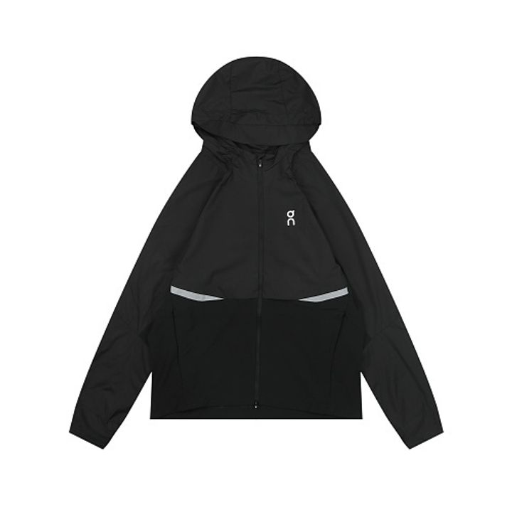 Front profile of the men's On Running Core Jacket in black, showcasing the lightweight windproof fabric, full-length front zipper, protective hood, white 'On' logo, and sleek reflective strips across the midsection for night safety.