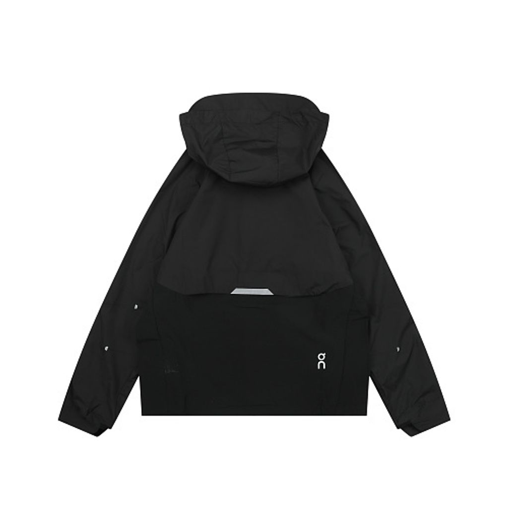Front profile of the men's On Running Core Jacket in black, showcasing the lightweight windproof fabric, full-length front zipper, protective hood, white 'On' logo, and sleek reflective strips across the midsection for night safety.