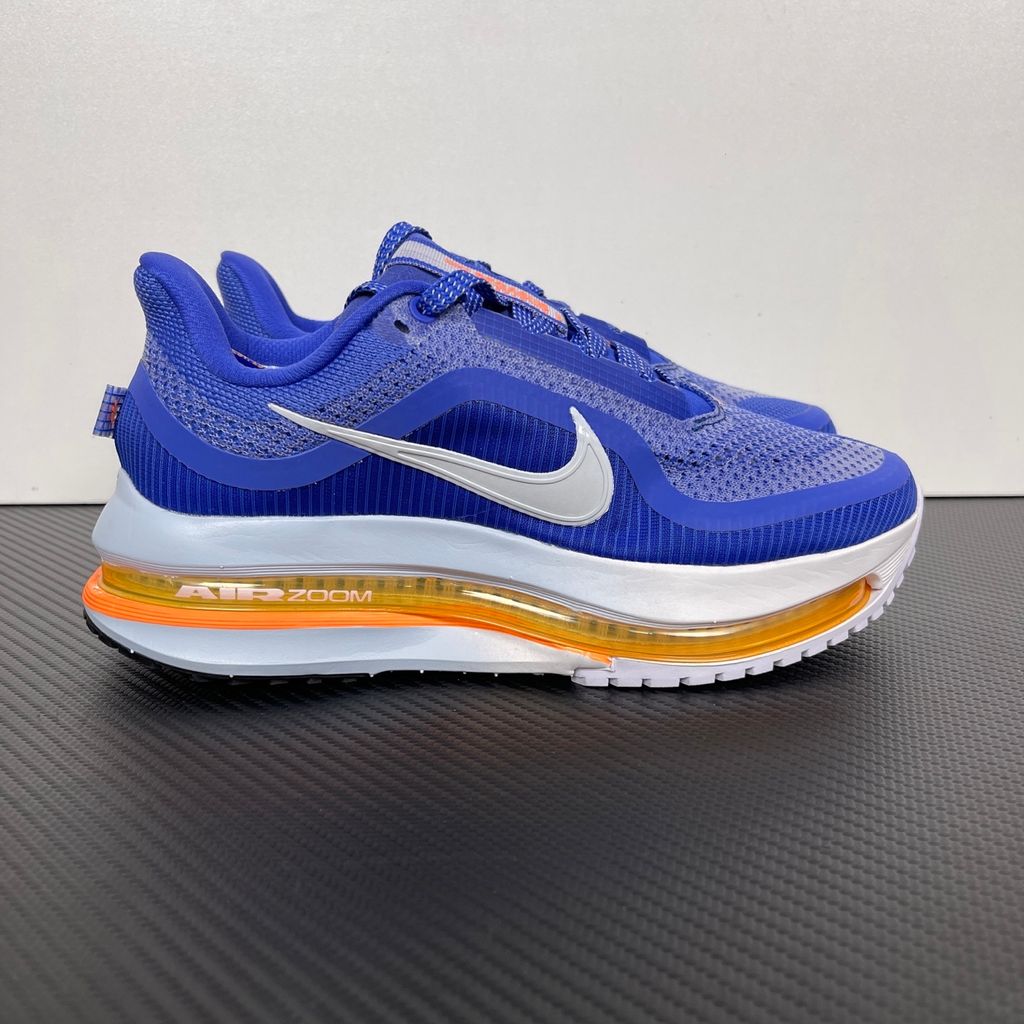 Side profile of the Nike Air Zoom Pegasus Premium, showcasing the vibrant Lapis blue engineered mesh upper, crisp white Nike Swoosh, energetic Total Orange accents, and the groundbreaking sculpted visible Zoom Air unit running through the midsole.