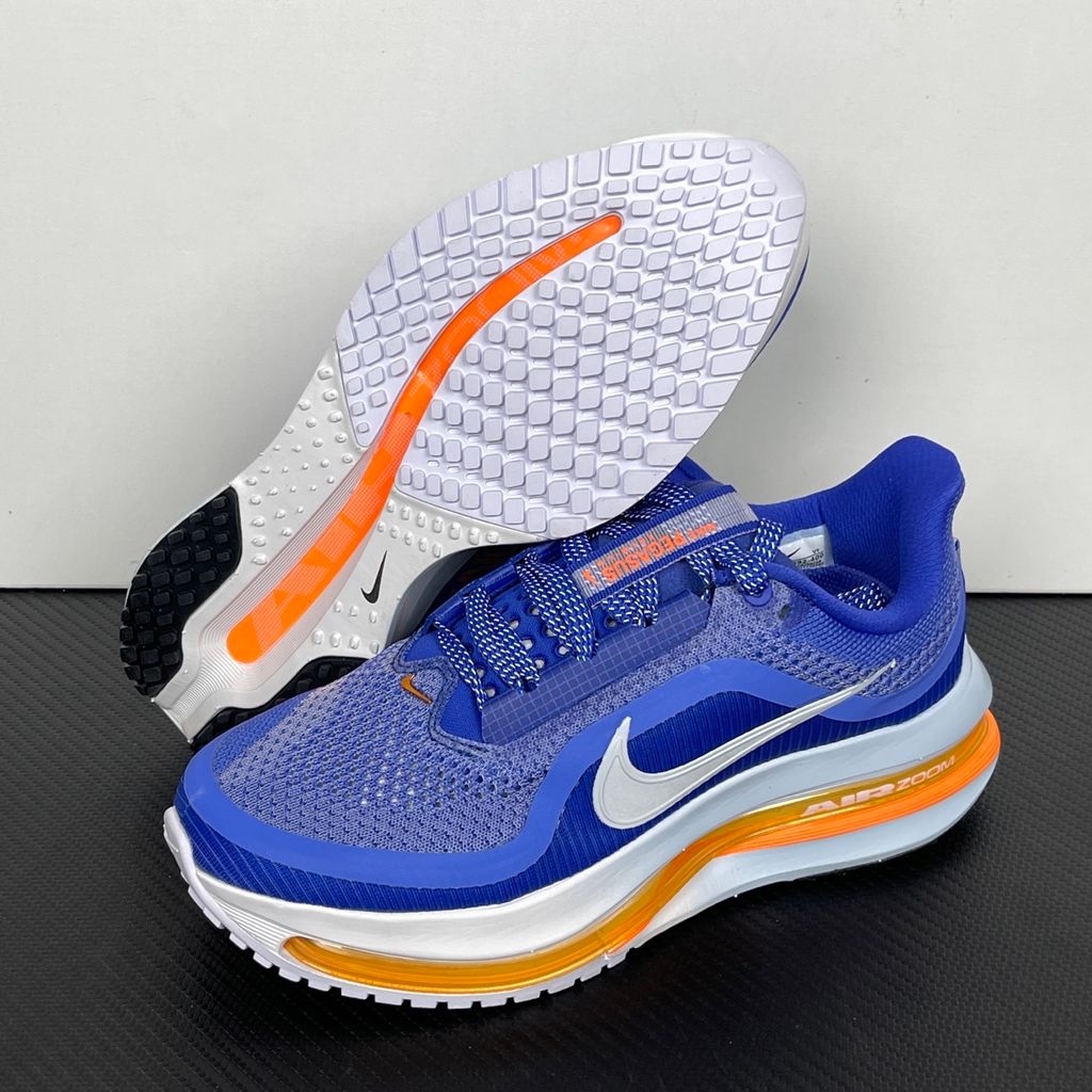 Side profile of the Nike Air Zoom Pegasus Premium, showcasing the vibrant Lapis blue engineered mesh upper, crisp white Nike Swoosh, energetic Total Orange accents, and the groundbreaking sculpted visible Zoom Air unit running through the midsole.