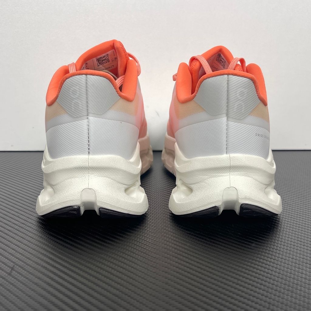 Side profile of the On Running Cloudtilt Remix sneaker, showcasing the vibrant warm orange 'Sunstone' mixed-material upper, quick-adjust speed lacing, and the crisp Ivory white CloudTec Phase® collapsing midsole.