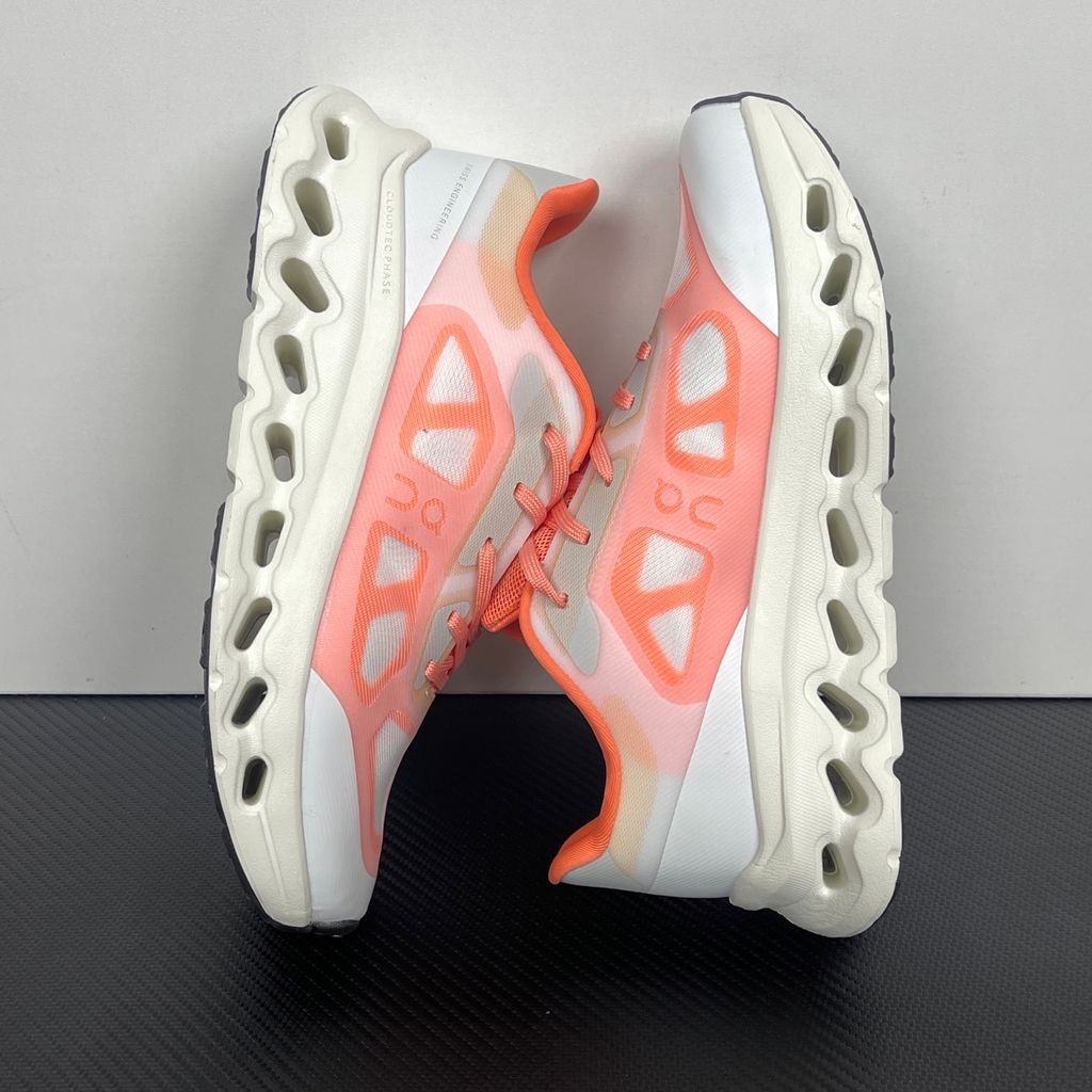 Side profile of the On Running Cloudtilt Remix sneaker, showcasing the vibrant warm orange 'Sunstone' mixed-material upper, quick-adjust speed lacing, and the crisp Ivory white CloudTec Phase® collapsing midsole.
