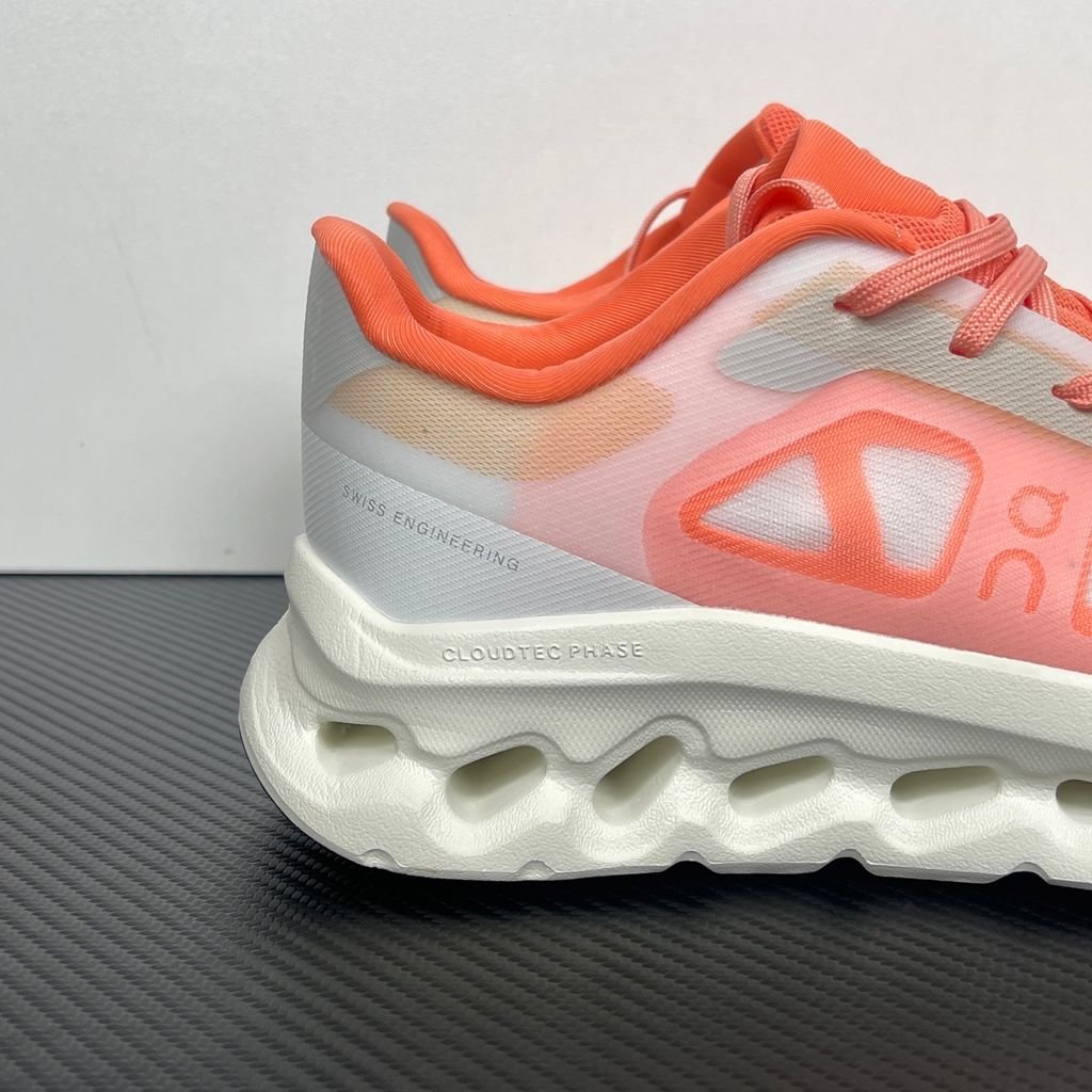 Side profile of the On Running Cloudtilt Remix sneaker, showcasing the vibrant warm orange 'Sunstone' mixed-material upper, quick-adjust speed lacing, and the crisp Ivory white CloudTec Phase® collapsing midsole.