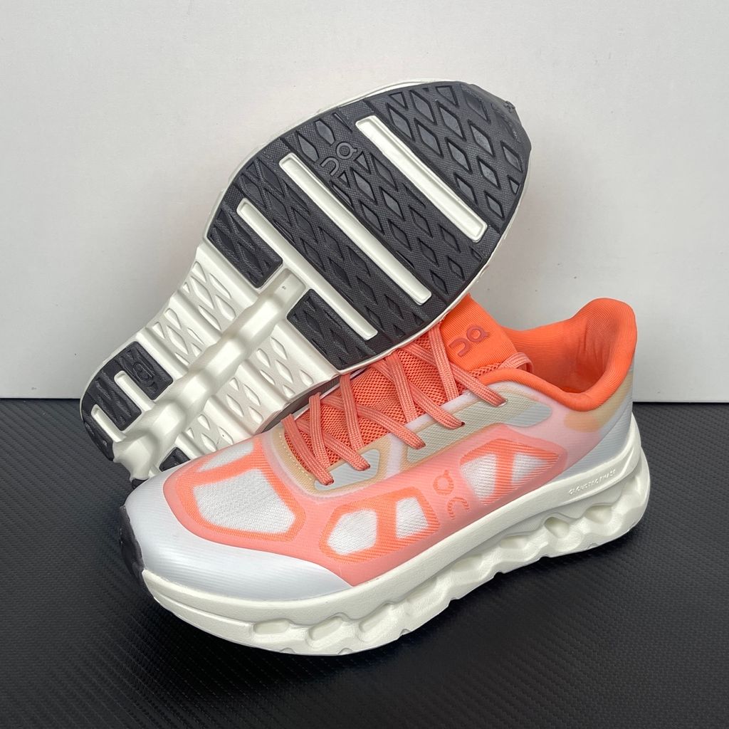 Side profile of the On Running Cloudtilt Remix sneaker, showcasing the vibrant warm orange 'Sunstone' mixed-material upper, quick-adjust speed lacing, and the crisp Ivory white CloudTec Phase® collapsing midsole.