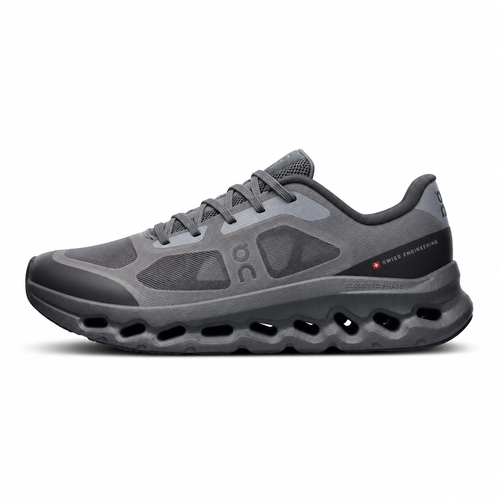 Side profile of the On Running Cloudtilt Remix sneaker in a monochromatic 'Triple Black' colorway, showcasing the mixed-material mesh and synthetic upper, quick-adjust speed lacing, and the stealthy black CloudTec Phase® collapsing midsole.