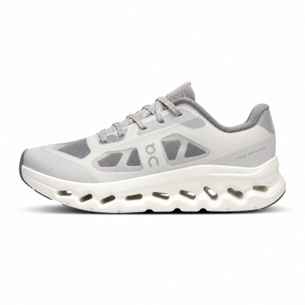 ide profile of the On Running Cloudtilt Remix sneaker, showcasing the mixed-material upper featuring a tonal grey breathable mesh base with matching grey synthetic overlays, speed lacing, and the distinctive white CloudTec Phase® collapsing midsole.