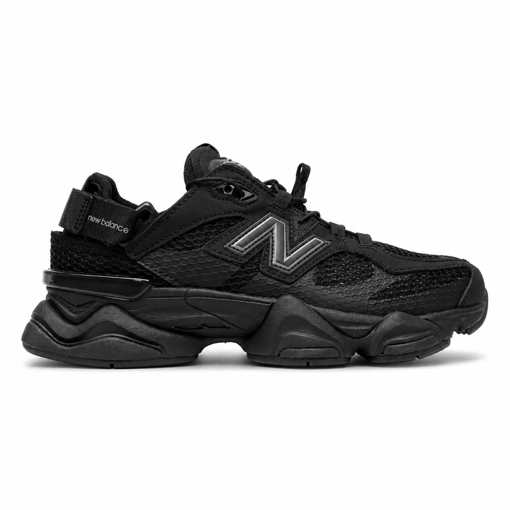 Side profile of the New Balance 9060 sneaker in the 'Summer Black' colorway, showcasing the retro-futuristic chunky midsole, black breathable mesh upper with tonal suede overlays, and the signature metallic 'N' logo on the side panel.