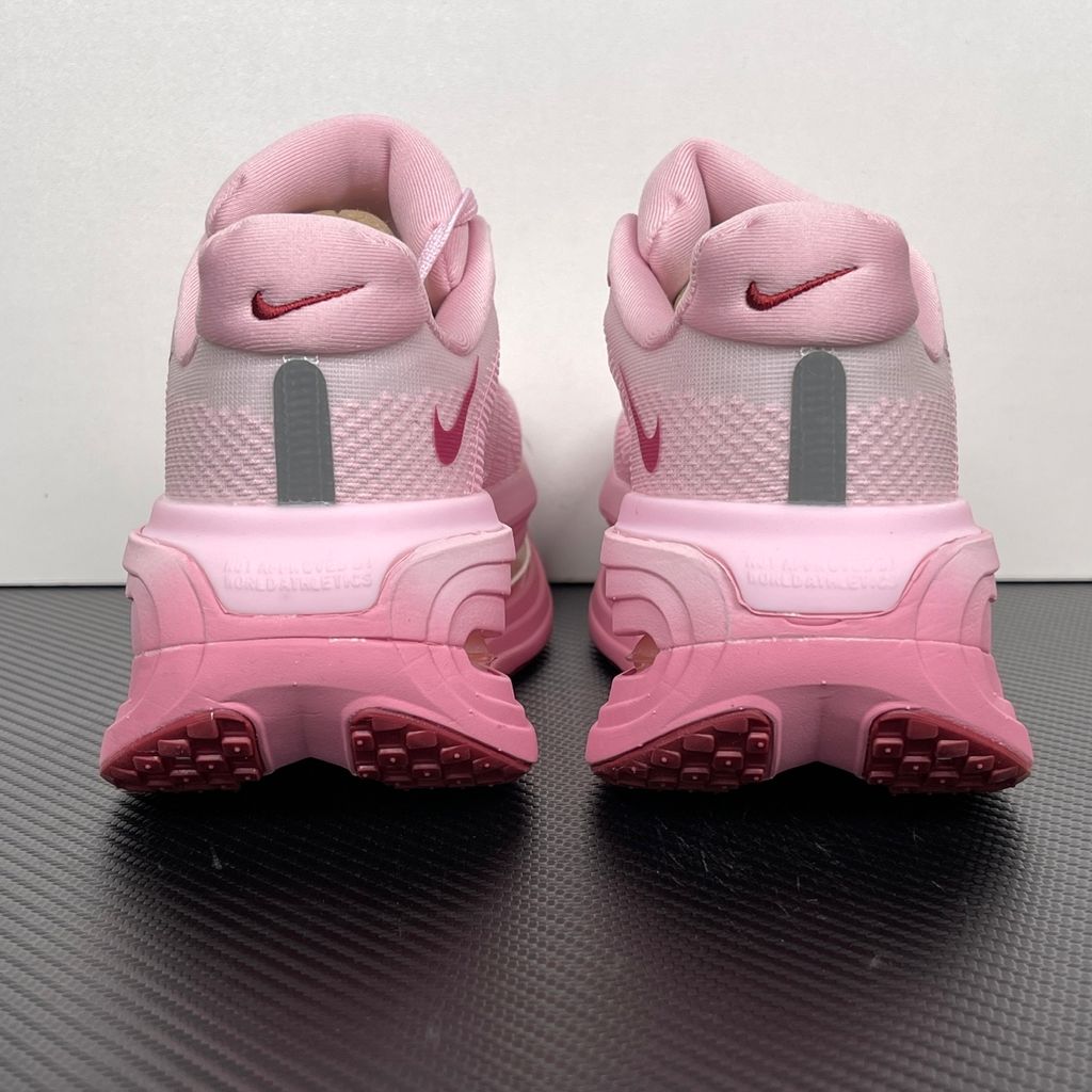 Side profile of the Nike Vomero Premium sneaker in the 'Pink Foam Light Magenta' colorway, showcasing the heavily layered breathable mesh upper, vibrant pink synthetic overlays, the iconic plastic midfoot cage, and the sculpted Cushlon midsole.