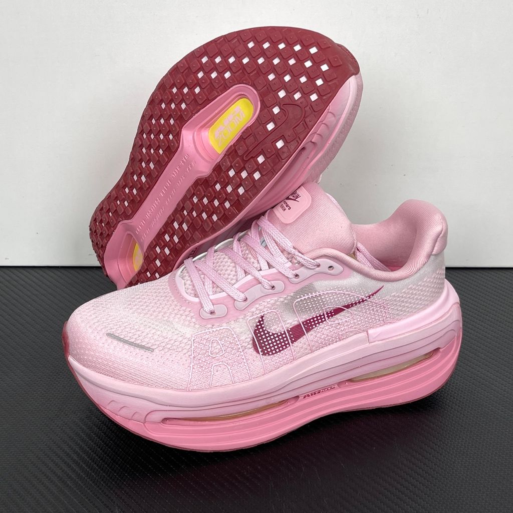 Side profile of the Nike Vomero Premium sneaker in the 'Pink Foam Light Magenta' colorway, showcasing the heavily layered breathable mesh upper, vibrant pink synthetic overlays, the iconic plastic midfoot cage, and the sculpted Cushlon midsole.