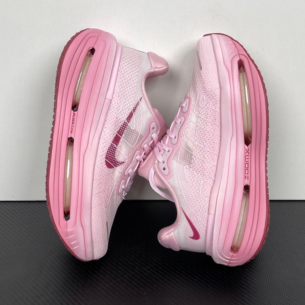 Side profile of the Nike Vomero Premium sneaker in the 'Pink Foam Light Magenta' colorway, showcasing the heavily layered breathable mesh upper, vibrant pink synthetic overlays, the iconic plastic midfoot cage, and the sculpted Cushlon midsole.