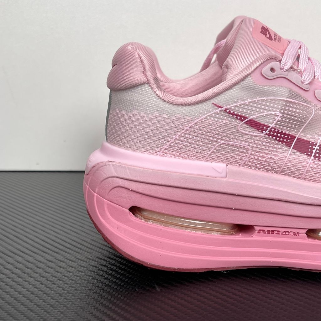 Side profile of the Nike Vomero Premium sneaker in the 'Pink Foam Light Magenta' colorway, showcasing the heavily layered breathable mesh upper, vibrant pink synthetic overlays, the iconic plastic midfoot cage, and the sculpted Cushlon midsole.