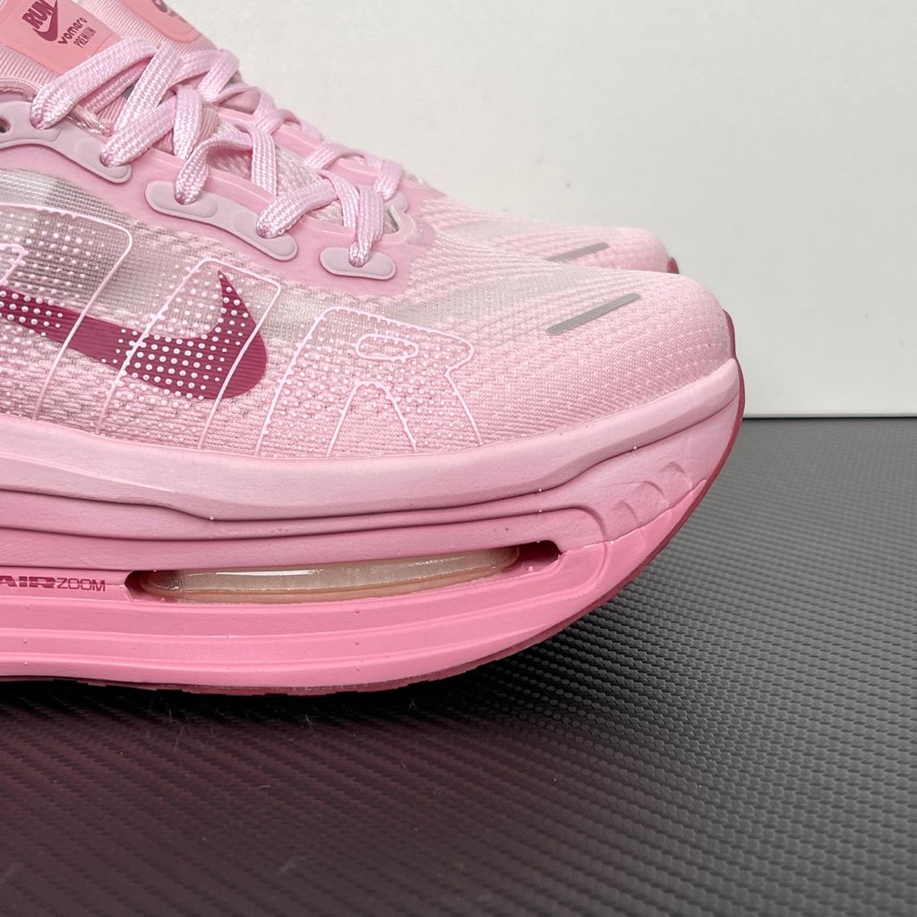 Side profile of the Nike Vomero Premium sneaker in the 'Pink Foam Light Magenta' colorway, showcasing the heavily layered breathable mesh upper, vibrant pink synthetic overlays, the iconic plastic midfoot cage, and the sculpted Cushlon midsole.