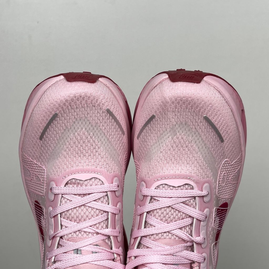 Side profile of the Nike Vomero Premium sneaker in the 'Pink Foam Light Magenta' colorway, showcasing the heavily layered breathable mesh upper, vibrant pink synthetic overlays, the iconic plastic midfoot cage, and the sculpted Cushlon midsole.