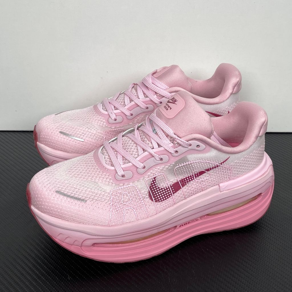 Side profile of the Nike Vomero Premium sneaker in the 'Pink Foam Light Magenta' colorway, showcasing the heavily layered breathable mesh upper, vibrant pink synthetic overlays, the iconic plastic midfoot cage, and the sculpted Cushlon midsole.