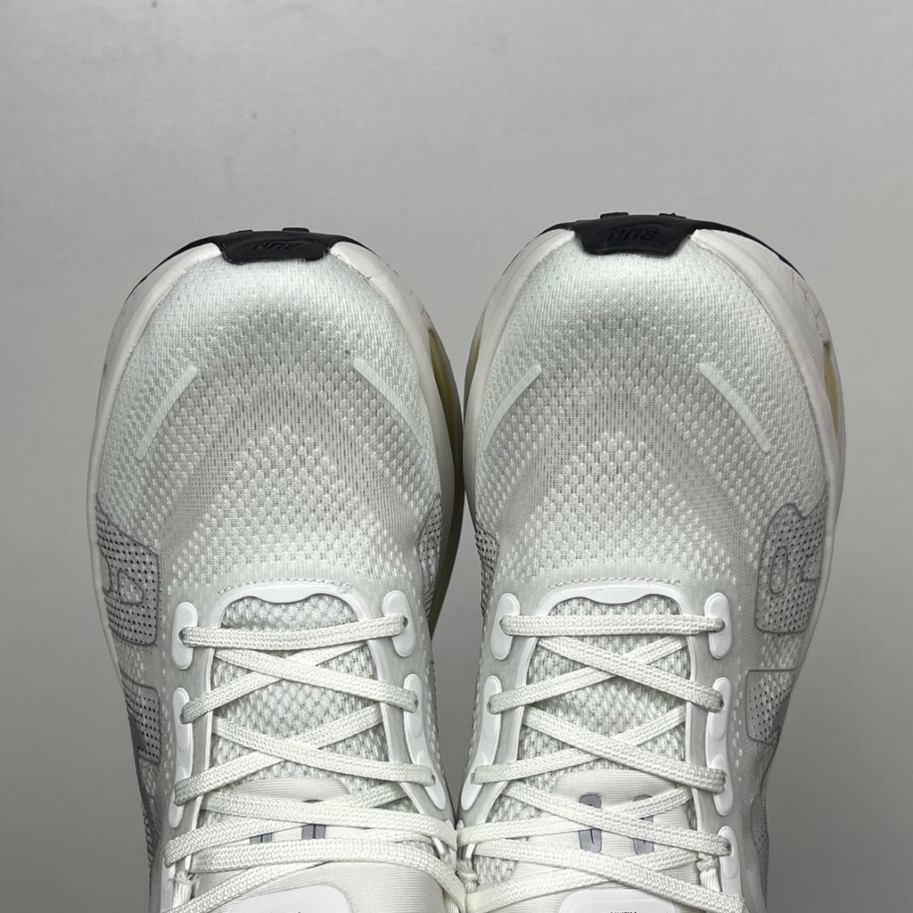 Side profile of the Nike Vomero Premium sneaker in the clean 'Chalk' colorway, showcasing the heavily layered breathable mesh upper, tonal off-white synthetic overlays, the iconic plastic midfoot cage, and the sculpted Cushlon midsole.
