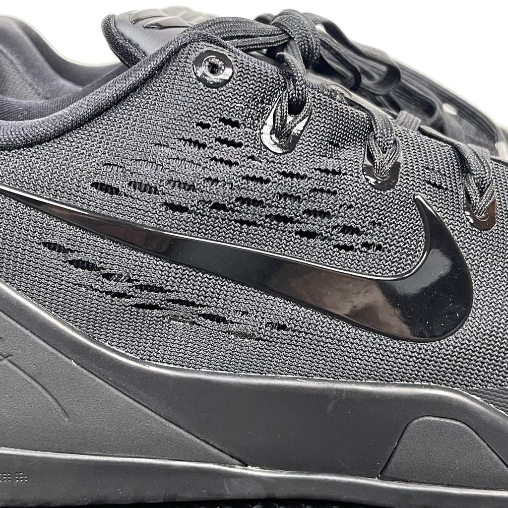 Side profile of the Nike Kobe 9 EM Low Protro TB sneaker in a monochromatic 'Triple Black' colorway, showcasing the stealthy Engineered Mesh upper, tonal black Swoosh, carbon fiber heel counter, and the signature black pressure-mapped outsole.