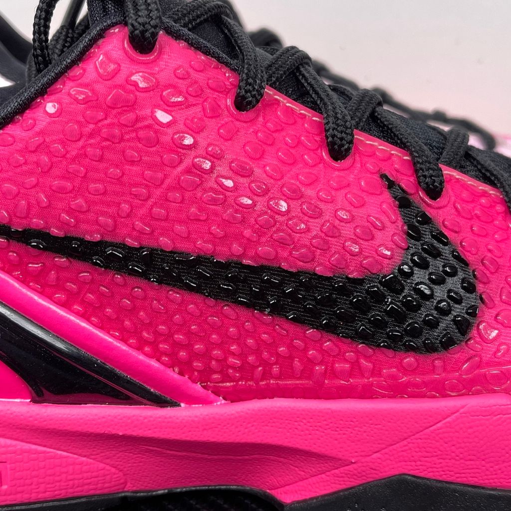 Side profile of the Nike Kobe 6 Protro 'Kay Yow Think Pink' 2026 sneaker, showcasing the vibrant pink snake-scale textured upper, contrasting white Swoosh, signature Kay Yow ribbon detailing on the heel, and the supportive heel counter.