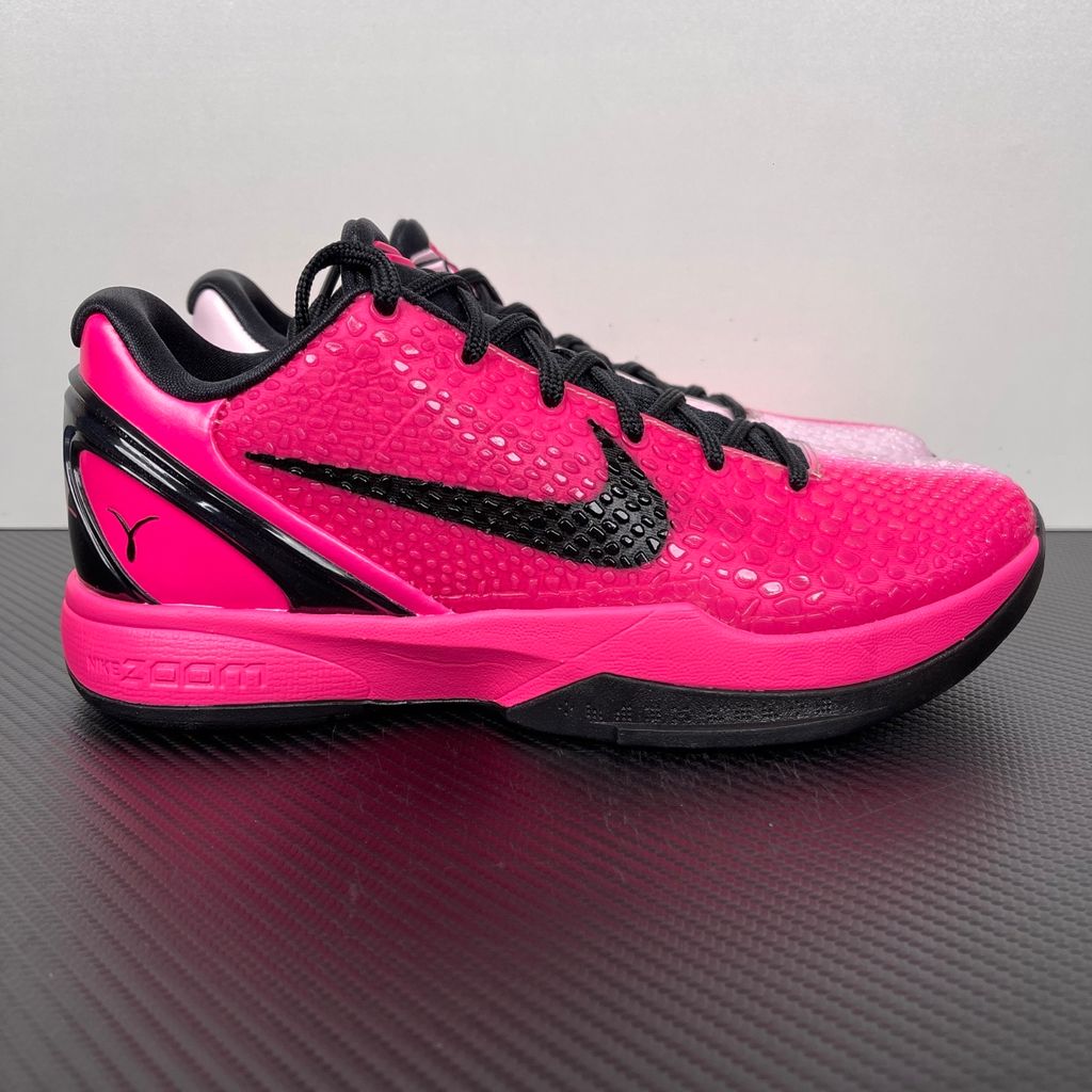 Side profile of the Nike Kobe 6 Protro 'Kay Yow Think Pink' 2026 sneaker, showcasing the vibrant pink snake-scale textured upper, contrasting white Swoosh, signature Kay Yow ribbon detailing on the heel, and the supportive heel counter.