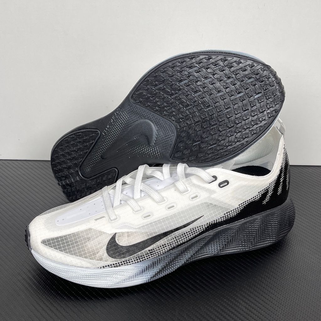 Side profile of the Nike Ava X sneaker in the crisp 'Summit White Black' colorway, showcasing a breathable white mesh upper, sharp contrasting black Swoosh and synthetic overlays, and a sculpted, responsive foam midsole.