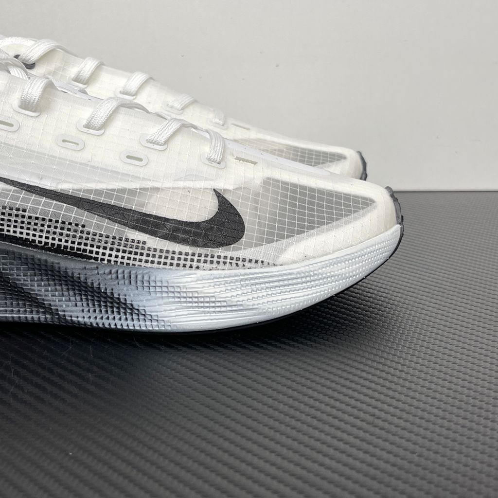 Side profile of the Nike Ava X sneaker in the crisp 'Summit White Black' colorway, showcasing a breathable white mesh upper, sharp contrasting black Swoosh and synthetic overlays, and a sculpted, responsive foam midsole.