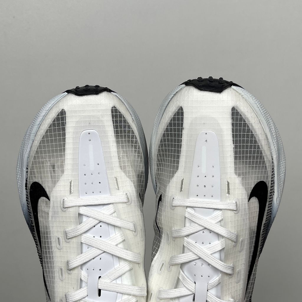 Side profile of the Nike Ava X sneaker in the crisp 'Summit White Black' colorway, showcasing a breathable white mesh upper, sharp contrasting black Swoosh and synthetic overlays, and a sculpted, responsive foam midsole.