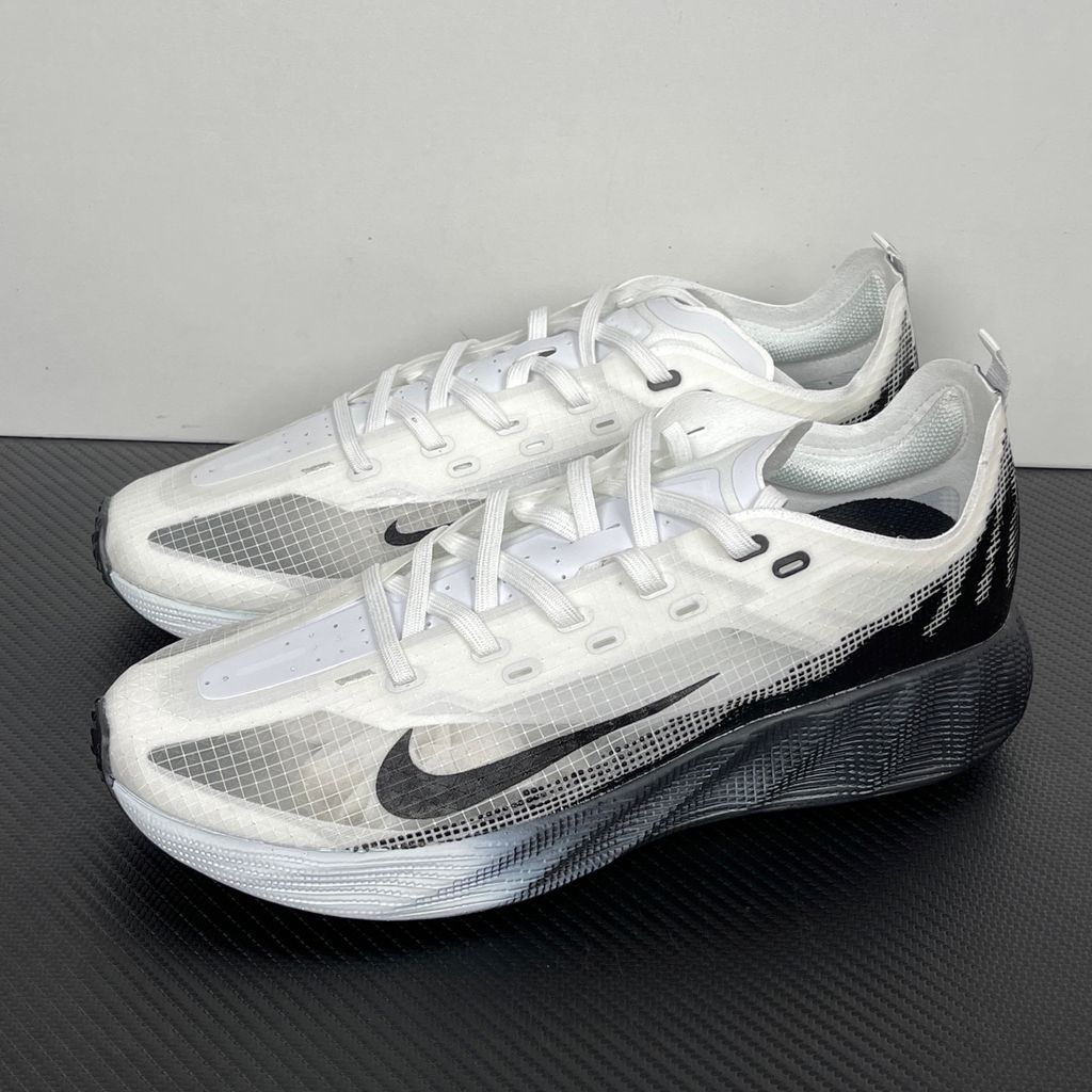 Side profile of the Nike Ava X sneaker in the crisp 'Summit White Black' colorway, showcasing a breathable white mesh upper, sharp contrasting black Swoosh and synthetic overlays, and a sculpted, responsive foam midsole.