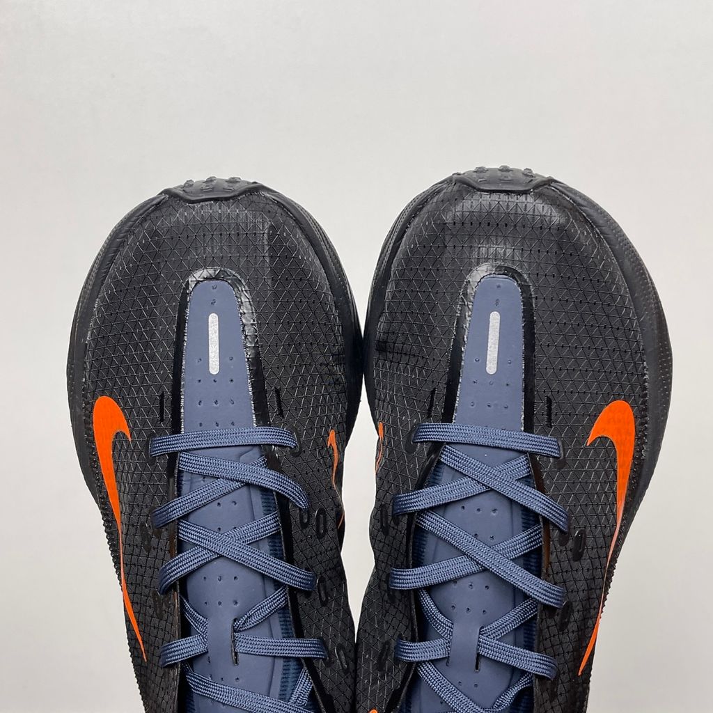 Side profile of the Nike Ava X sneaker in the 'Dark Obsidian Bright Mandarin' colorway, showcasing a deep navy blue breathable mesh upper, vibrant orange contrasting Swoosh and synthetic overlays, and a sculpted, responsive foam midsole.