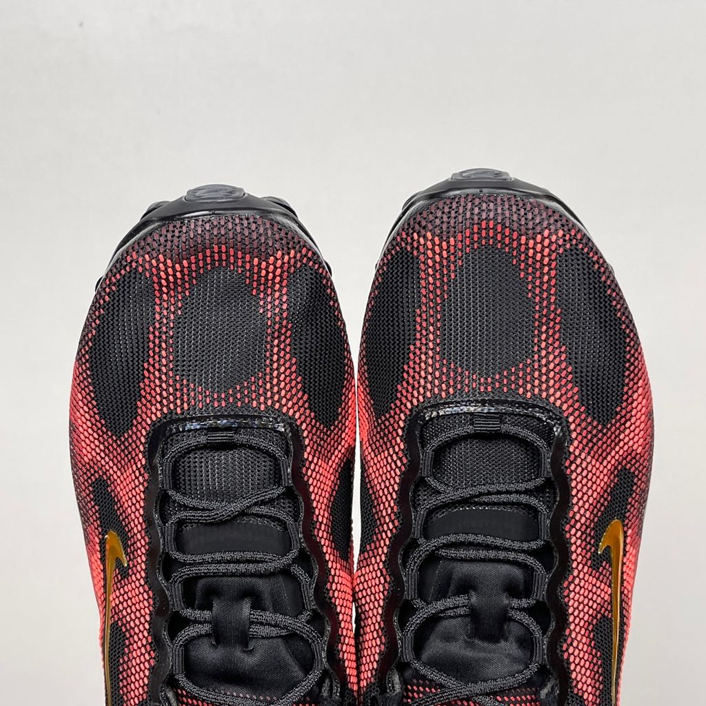 Side profile of the Nike Air Liquid Max sneaker in the 'Bright Crimson Fire Red' colorway, showcasing a fluid, aerodynamic mesh upper with vibrant red and crimson synthetic overlays, and a prominent visible Max Air cushioning unit in the heel and midfoot.